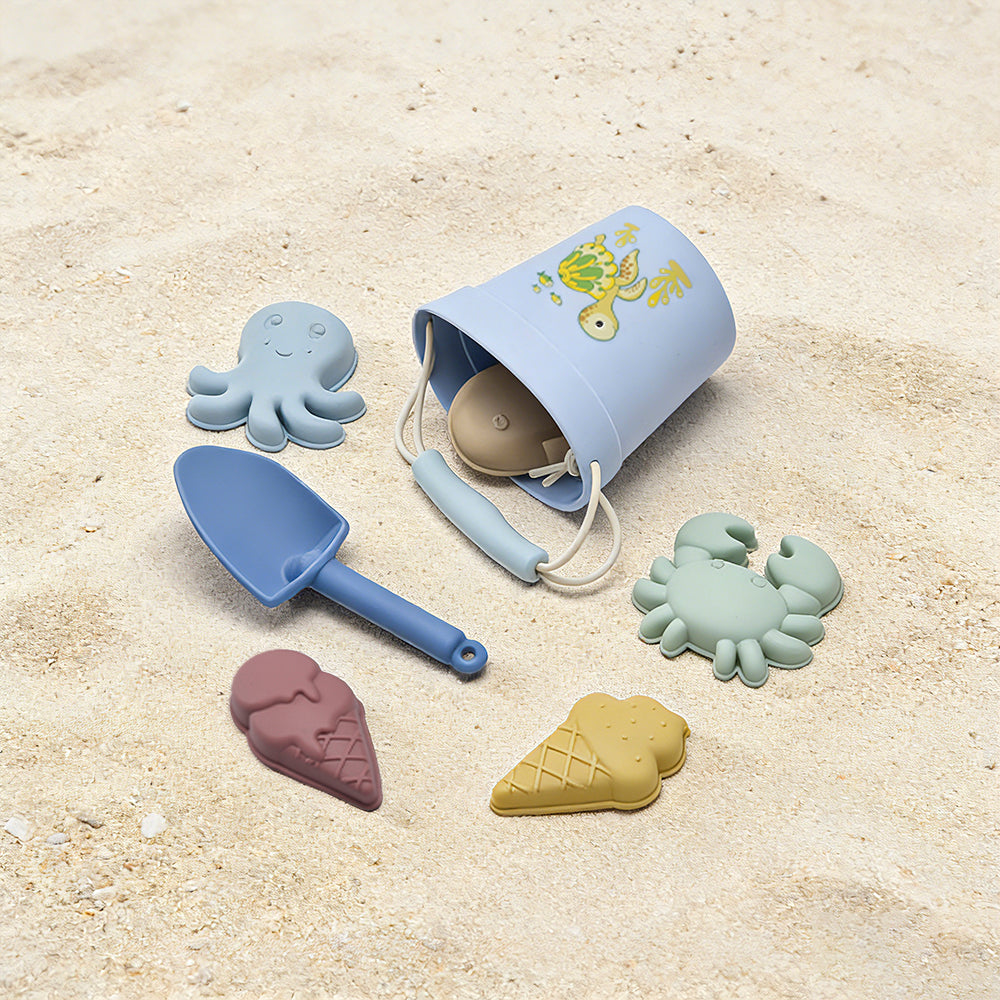 Set of beach toys including a blue bucket, spade, and molds on sand #tortoise
