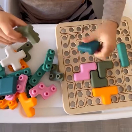 Children playing with colorful building blocks on a grid mat