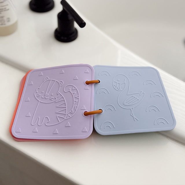 Two silicone coasters with animal designs on a white surface.