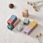 Set of colorful number blocks on a textured surface with dried flowers.