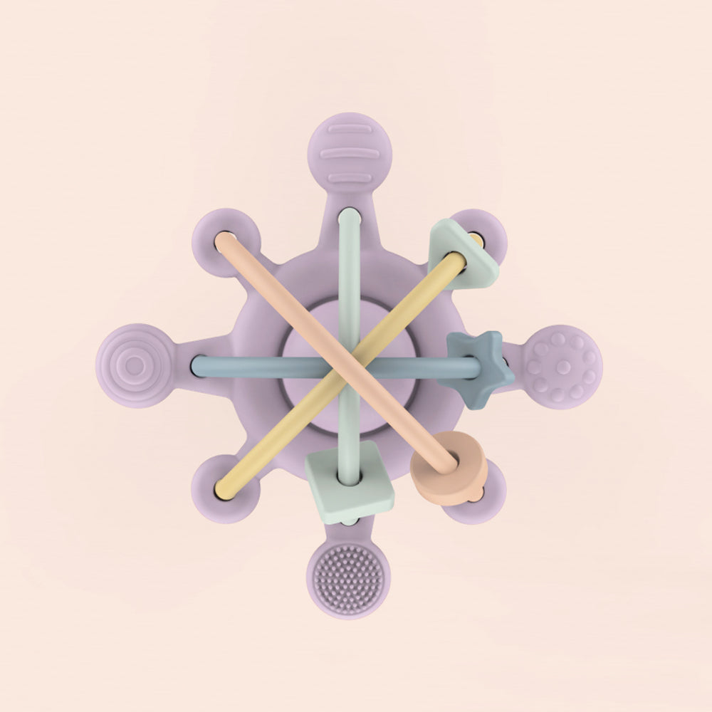 Colorful baby teething ring with wooden and silicone components on a beige background