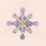 Colorful baby teething ring with wooden and silicone components on a beige background