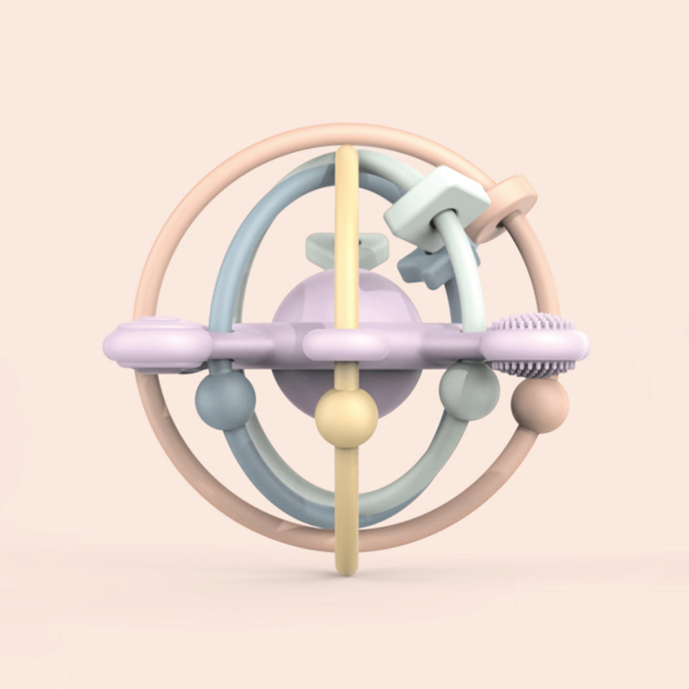 Colorful baby teething ring on a light pink background