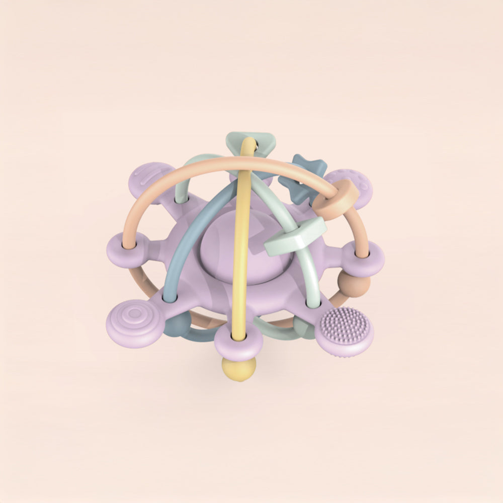 Colorful baby teething ring on a light pink background