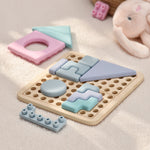 Baby teething toy with pastel colored geometric shapes on a soft surface 