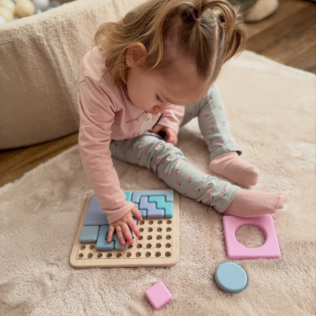 Child playing with a shape sorting toy on a carpeted floor. 
