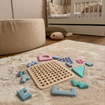 Wooden puzzle with colorful interlocking pieces on a carpeted floor. 