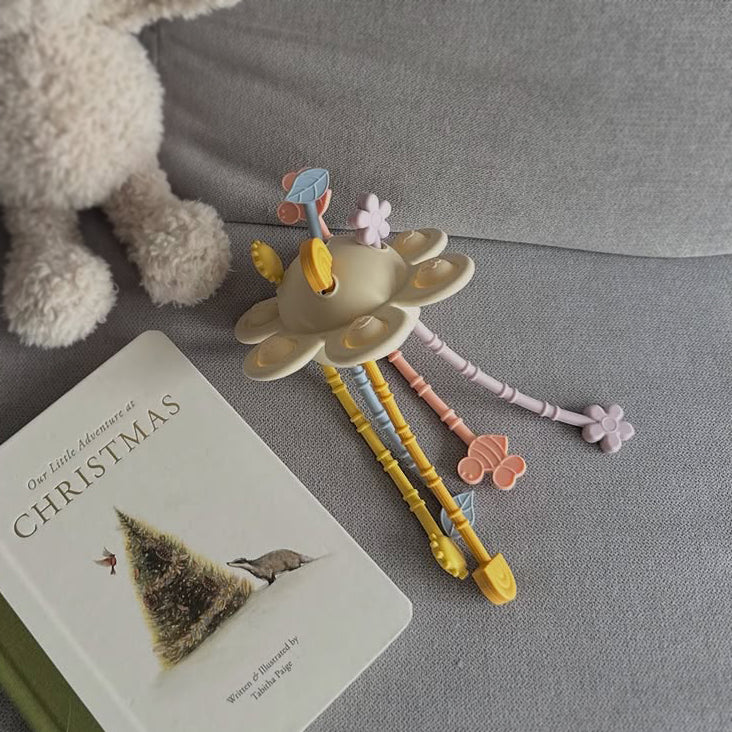 Decorative pen holder with pens on a book titled 'Our Little Adventure at Christmas' on a gray surface.