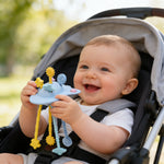 Baby sitting in a stroller holding a toy with a blurred outdoor background
