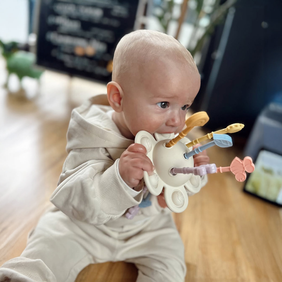 Baby playing with a colorful toy in a casual indoor setting