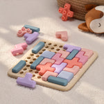 Colorful puzzle toy on a soft surface with additional toys in the background 