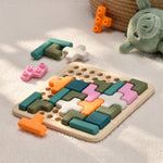 Colorful wooden puzzle toy on a soft surface with a plush turtle toy in the background. 