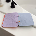 Two silicone coasters with animal designs on a white surface. 