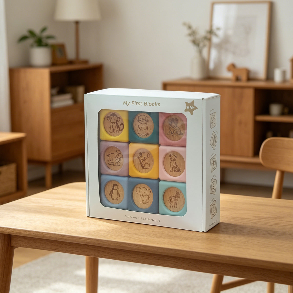 Box of 'My First Blocks' educational toy on a wooden table with a home interior background.