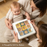 A baby gift set in a white box with nine colorful wooden toy pieces, held by a woman and a baby in a cozy indoor setting. The text overlay at the bottom reads 'A Thoughtful Gift for Babies'.