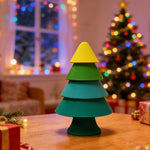 Colorful Christmas tree-shaped lamp on a table with a decorated room in the background