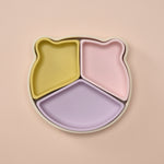 Three-section plate with yellow, pink, and purple sections on a beige background 