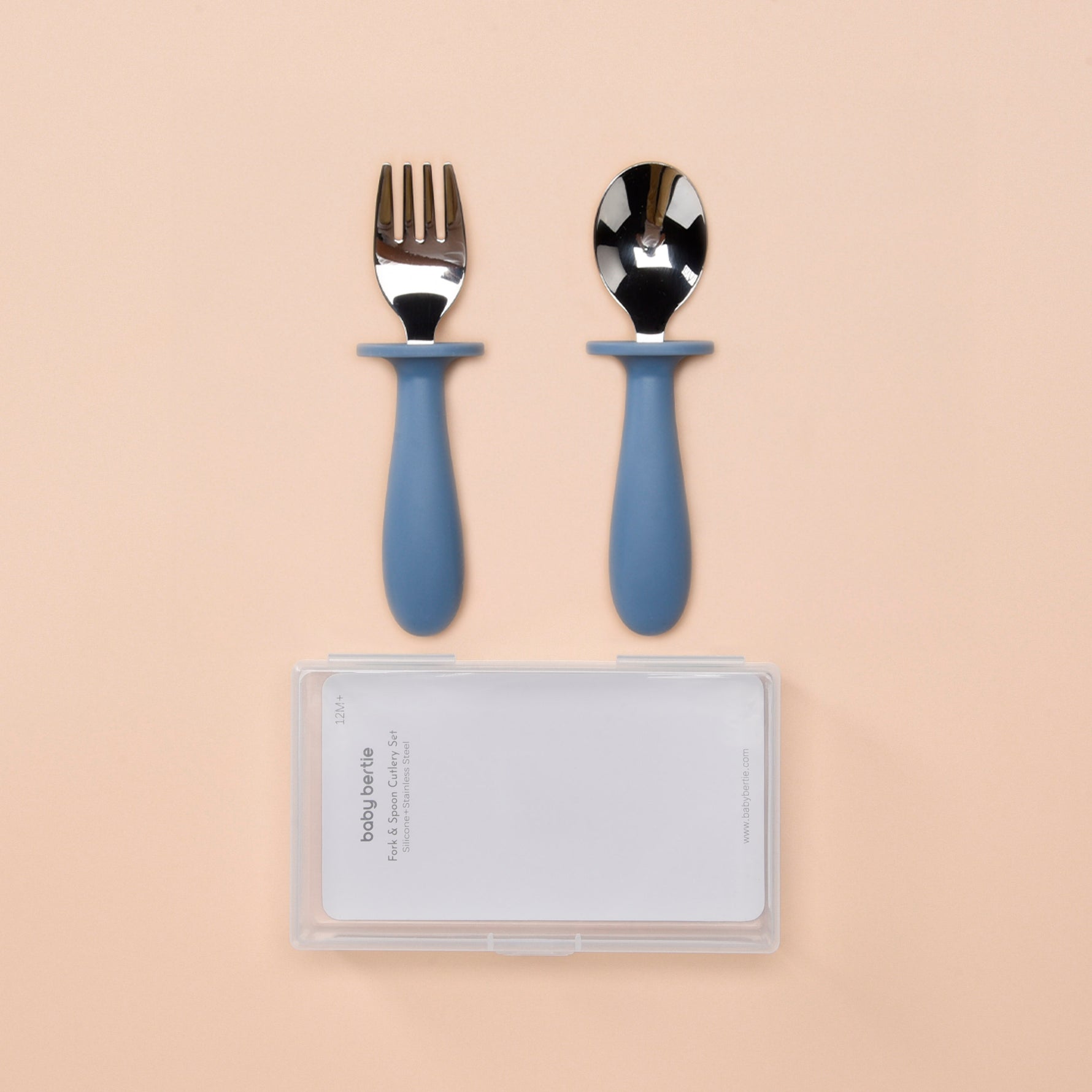 Set of silver fork and spoon with blue handles on a beige background 