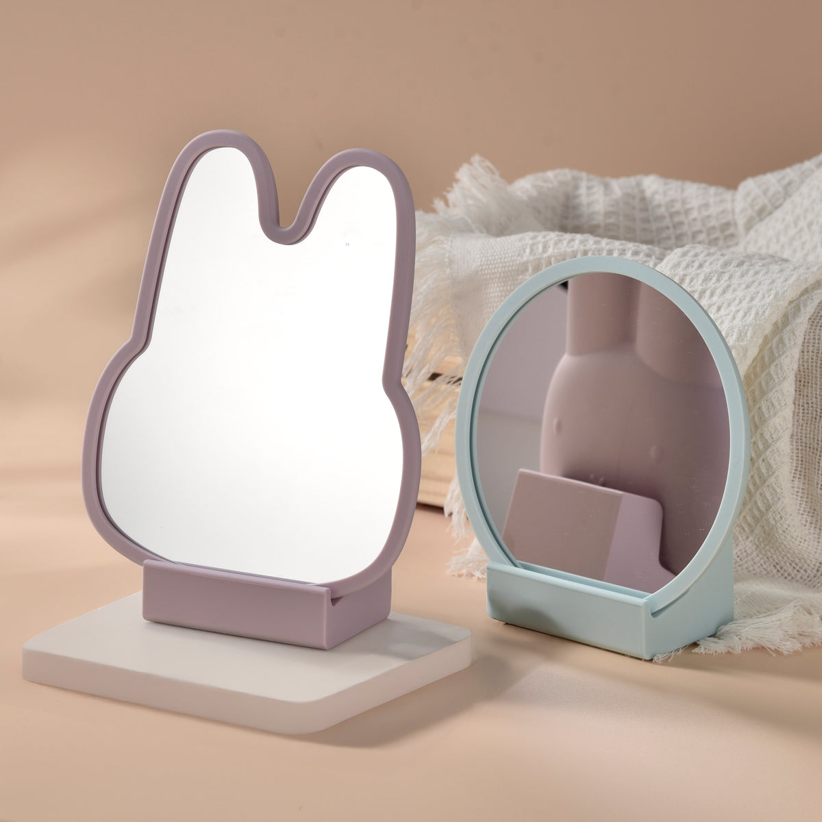 Two small mirrors with cat-shaped frames on a beige background