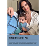 A woman and a baby are shown using a blue silicone feeding set with a divided plate, bowl, and spoon. The image includes a text banner at the bottom that reads 'First Bites Full Kit' with a descriptive subtitle.