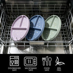 Three oval divided baby plates in pastel purple, blue, and sage green with small white polka dots, shown inside a dishwasher rack. A black banner at the bottom lists dishwasher safe, microwave safe, food safe, and BPA free icons.